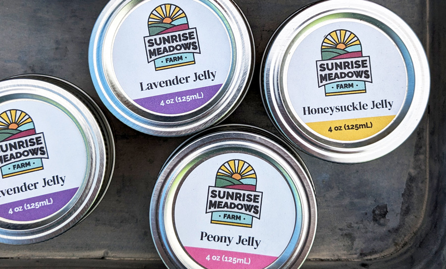 Jelly jars with Sunrise Meadows labels on the top